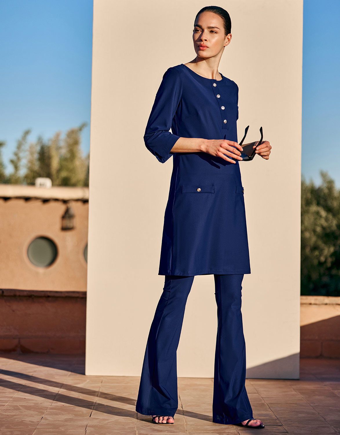 Model standing in the Lima Sapphire Blue trousers in jersey lycra with a matching tunic.