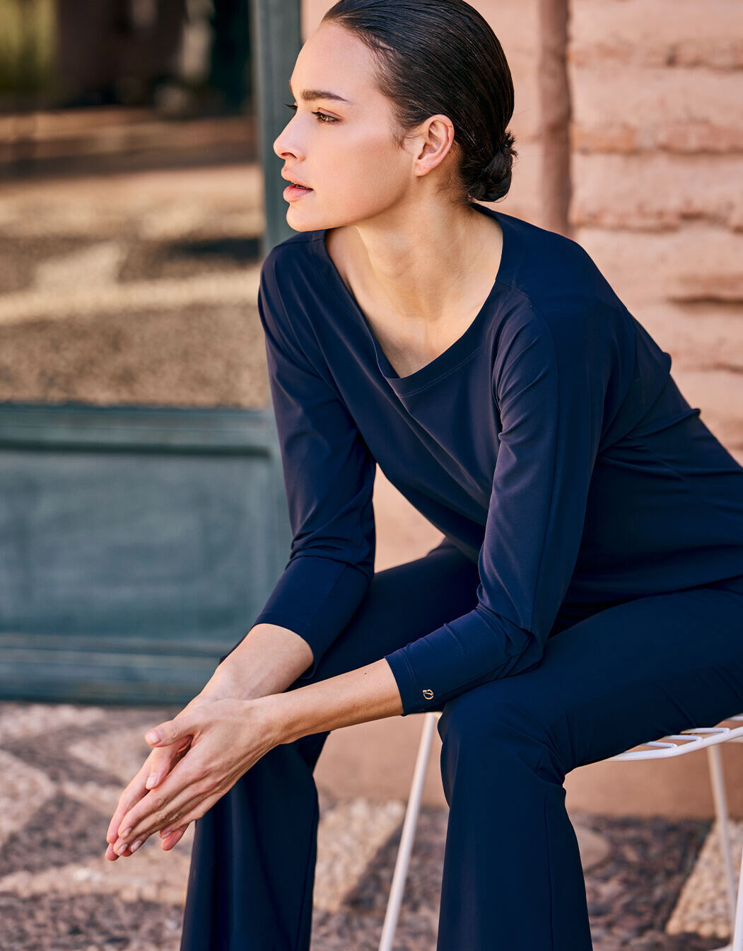 Model seated in the Reese Midnight Blue tunic in jersey lycra with matching trousers.