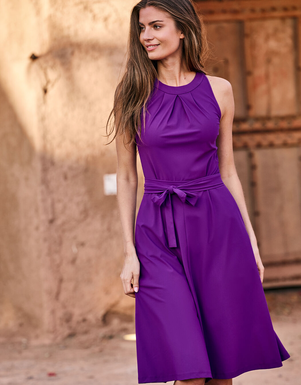 Model standing in the Juno Violet dress in jersey lycra with a halter neckline.