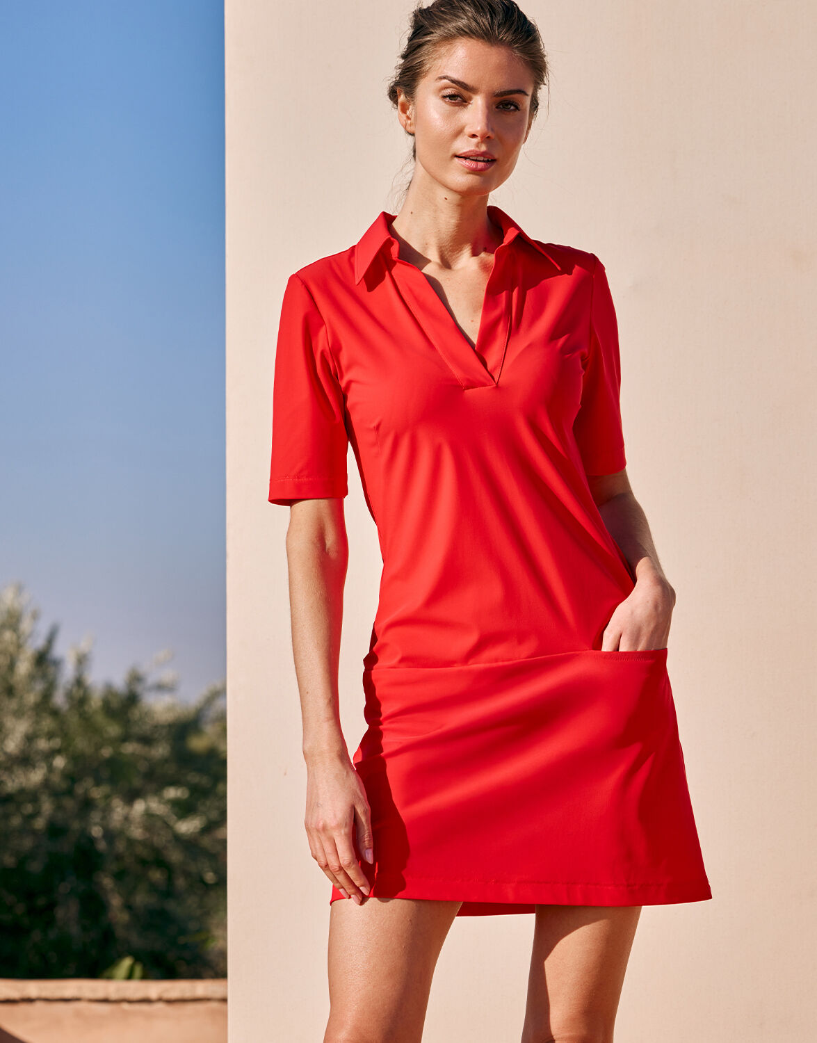 Model outdoors in the Amara Hibiscus polo dress in jersey lycra, front view.