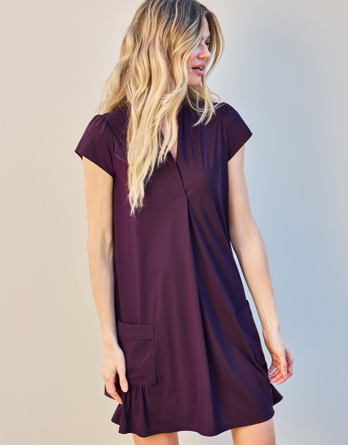 Model standing in the Liana Deep Aubergine dress in jersey lycra with patch pockets.