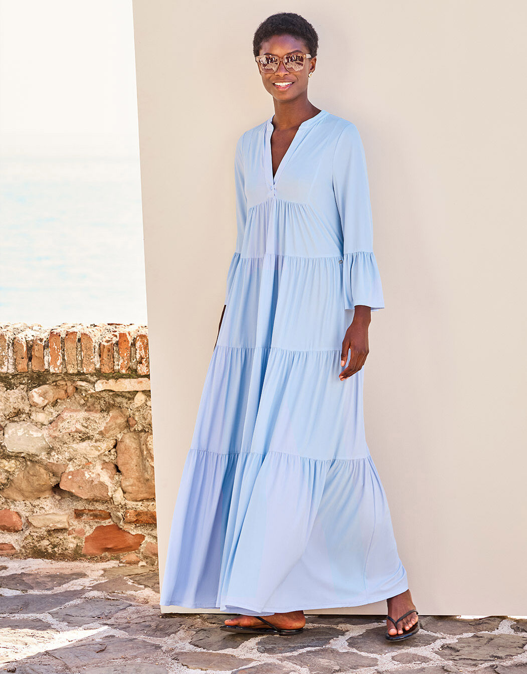Model standing in the Liora Sky Blue dress in jersey lycra with a tiered maxi skirt.
