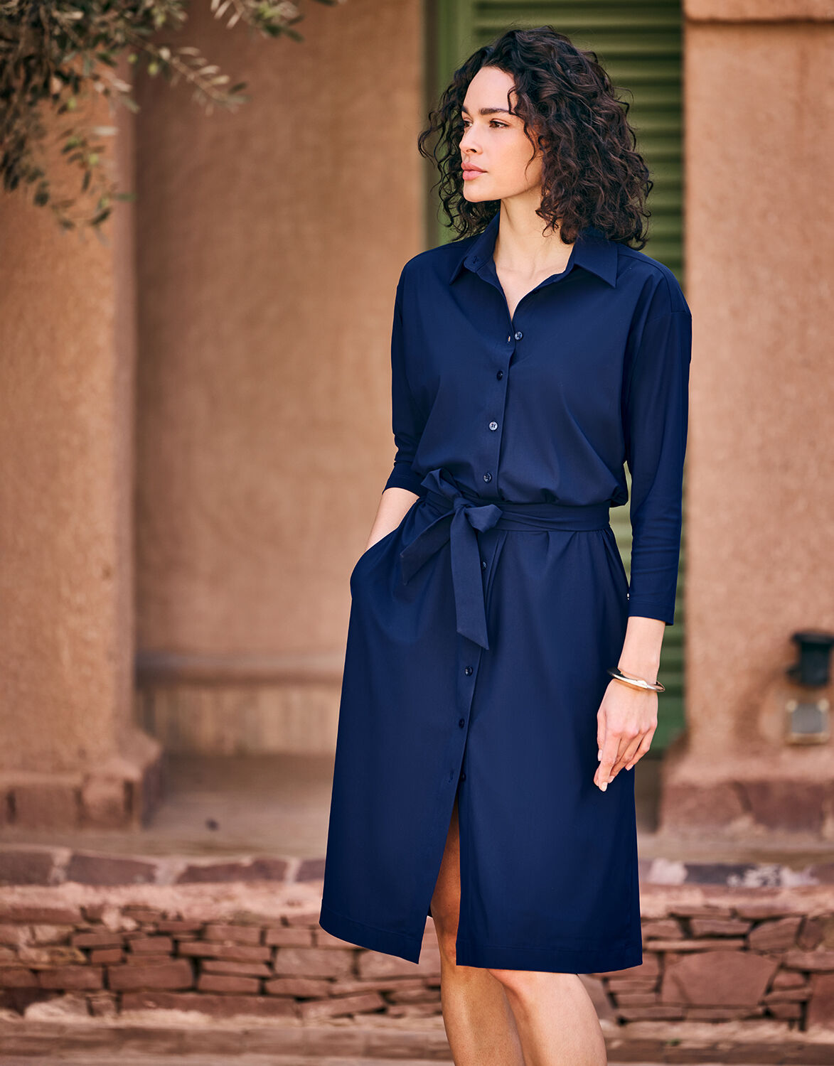 Model outdoors in the Angela Sapphire Blue shirt dress in jersey lycra with a belt.