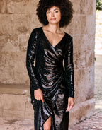 Elegant black sequin dress with a deep V-neck and long sleeves, detailed with ruffles and a high front slit.