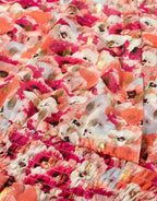 Bright pink and orange floral fabric with gold accents, close-up of the colorful and vibrant floral print on cotton.