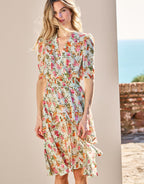 Woman poses in an elegant summer floral dress with short sleeves, ideal for sunny days and casual outings.