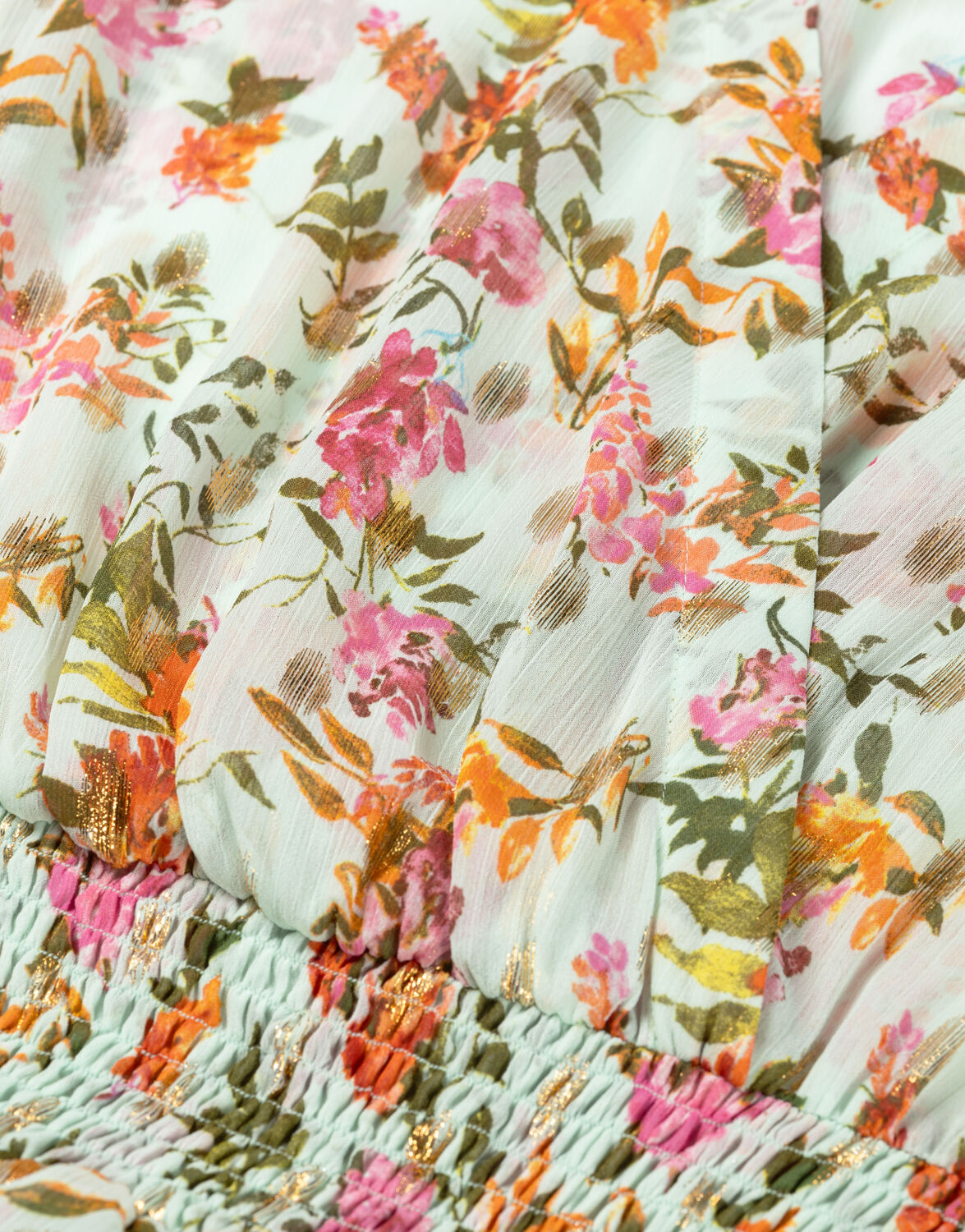 Floral dress made of lightweight fabric with a colorful floral pattern and subtle gold accents, perfect for a summer look.