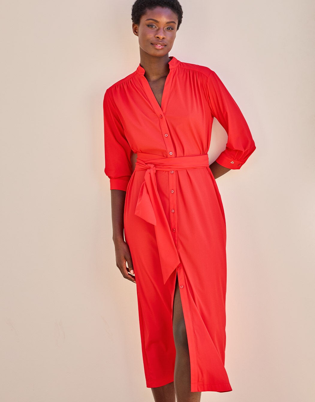 Model standing in the Ethel Hibiscus dress in jersey lycra with a tie belt at the waist.