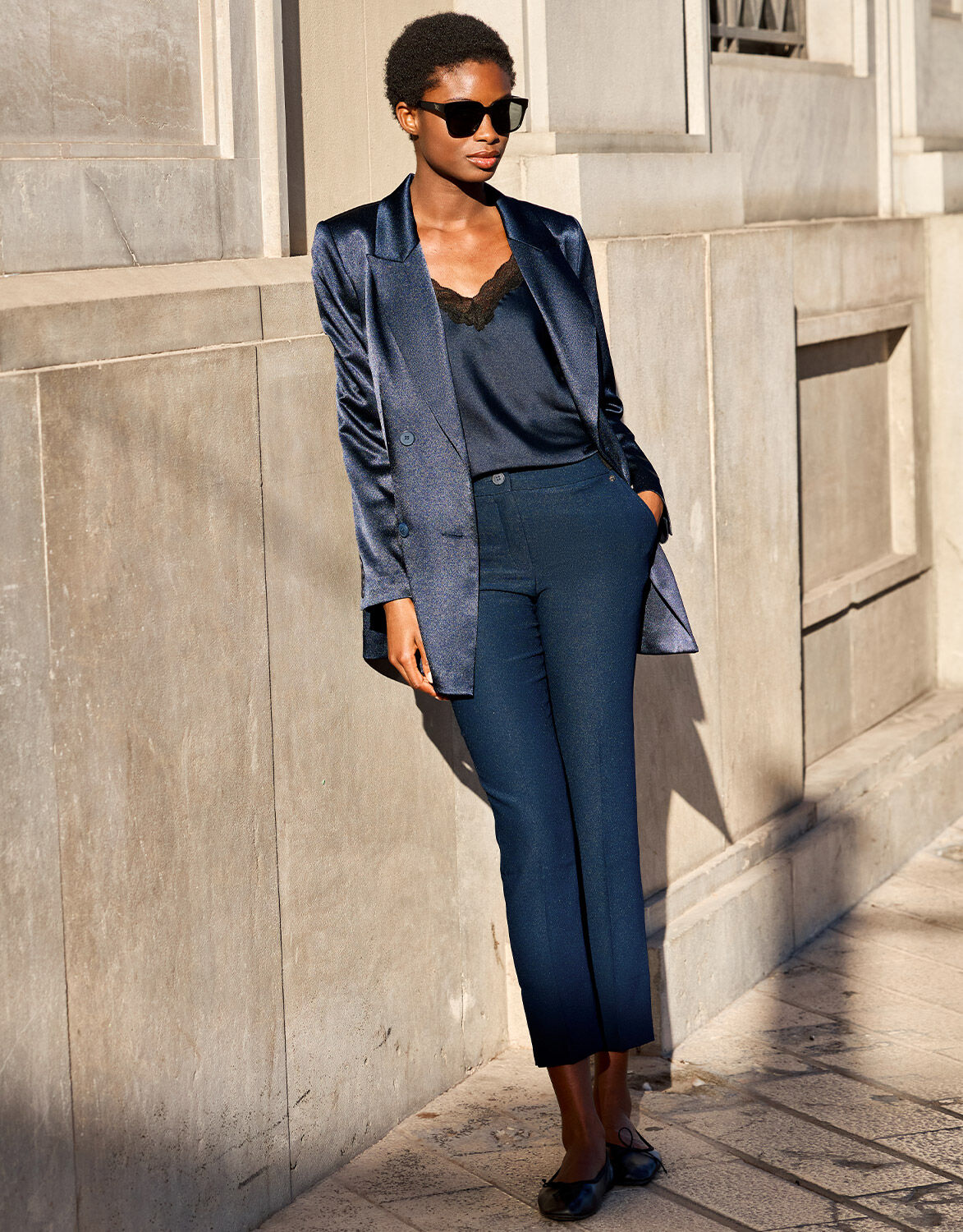 Model standing in the Seoul Midnight Blue trousers in crepe satin with a satin blazer.