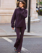Model walking in the Giovanna Deep Aubergine jumper in alpaca blend with matching trousers.