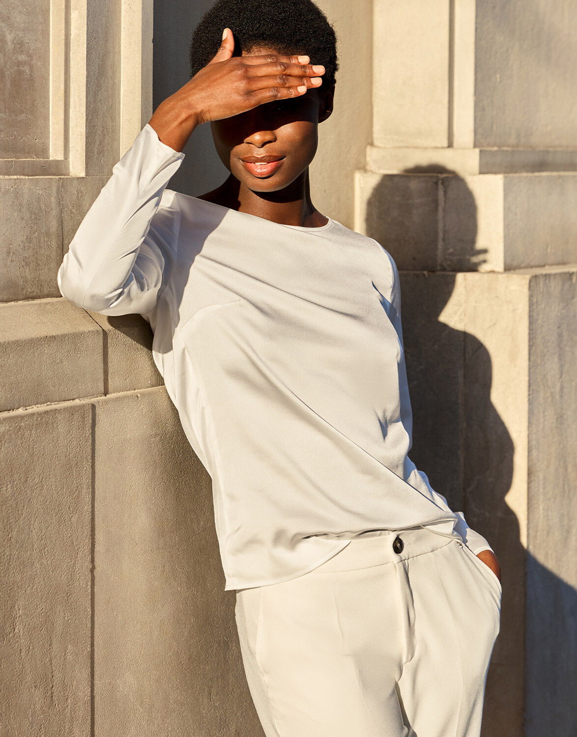 Model standing in the Dorian Ivory top in satin with matching ivory trousers.