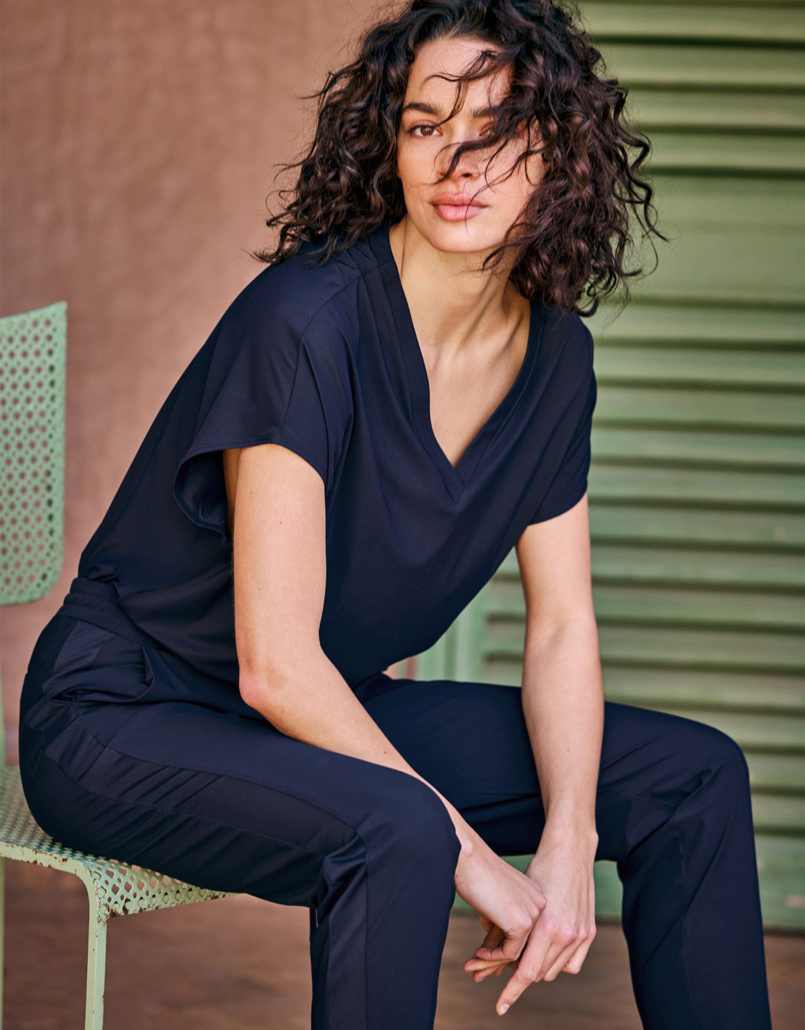 Model seated in the Liz Midnight Blue top in jersey lycra with matching trousers.