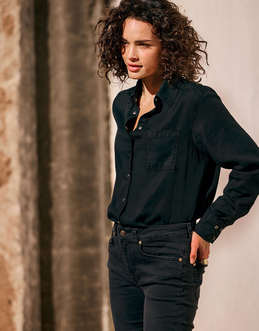 Model wearing the Andrea Black shirt in lyocell denim with black jeans.