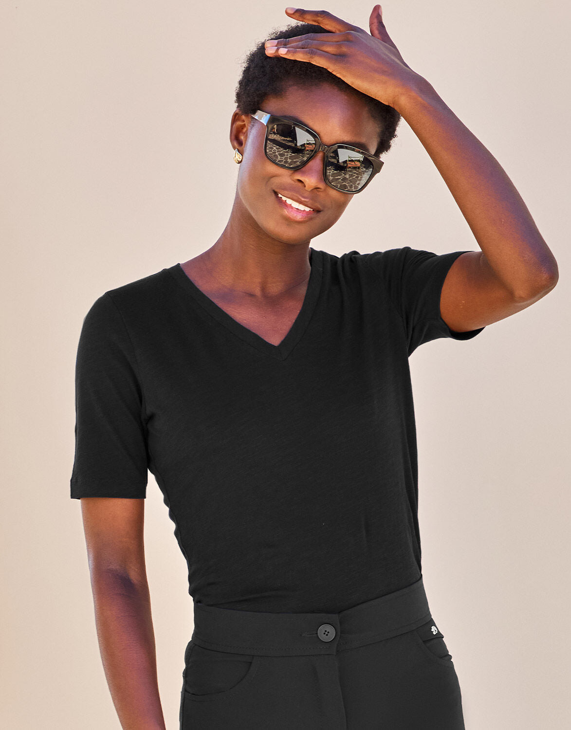 Model standing in the Chiara Black T-shirt in cotton with a V-neck and short sleeves.