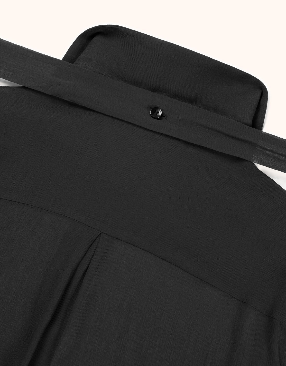Black shirt fabric with a refined texture, including a reinforced collar with a single black button.