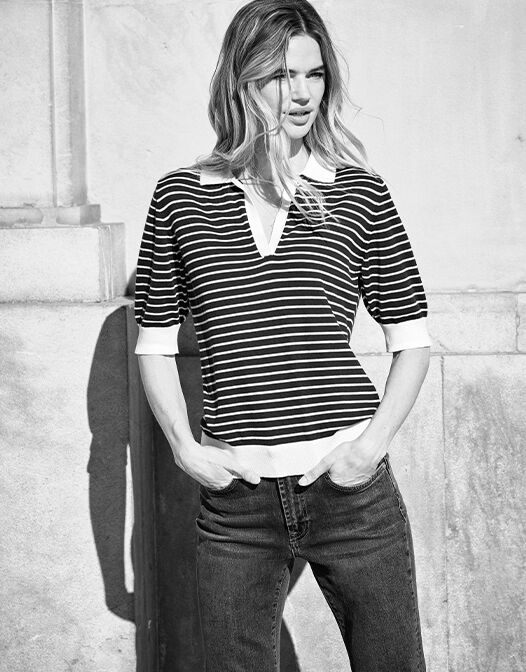 Model standing in the Charly Midnight Blue Stripe top in organic certified cotton with jeans.