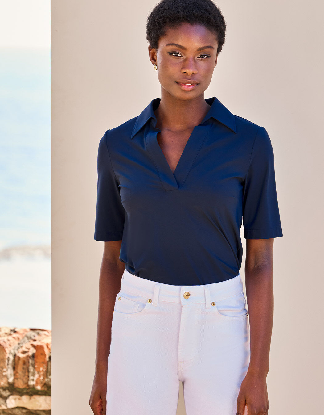 Model standing in the Evi Midnight Blue top in jersey lycra with a polo collar.