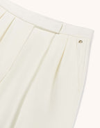Detail of the Toledo Ivory trousers in crepe satin, showing the waistband and pleat.