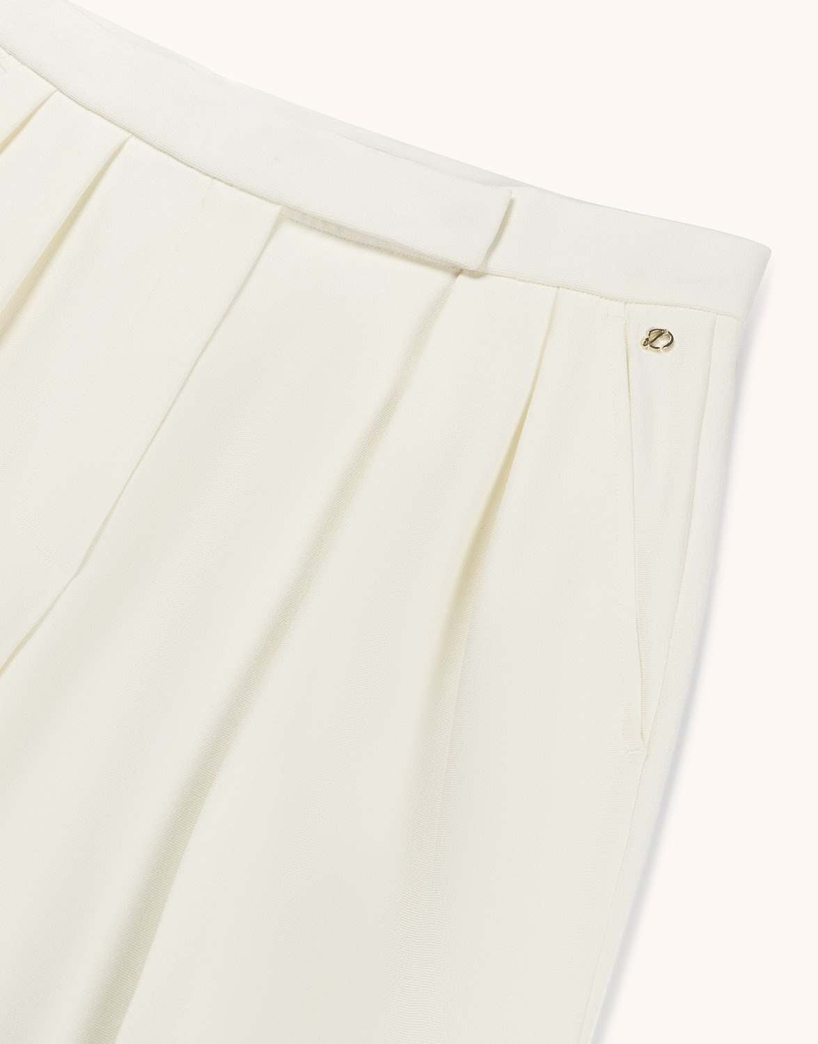 Detail of the Toledo Ivory trousers in crepe satin, showing the waistband and pleat.
