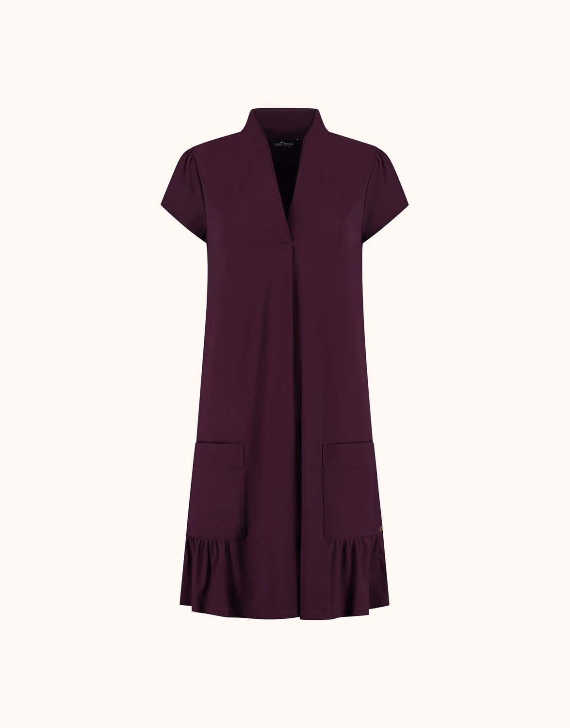 Packshot of the Liana Deep Aubergine dress in jersey lycra with a ruffled hem and pockets.