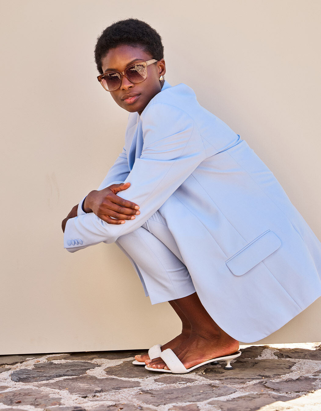 Model crouching in the Beau Dusty Blue blazer with matching shorts.