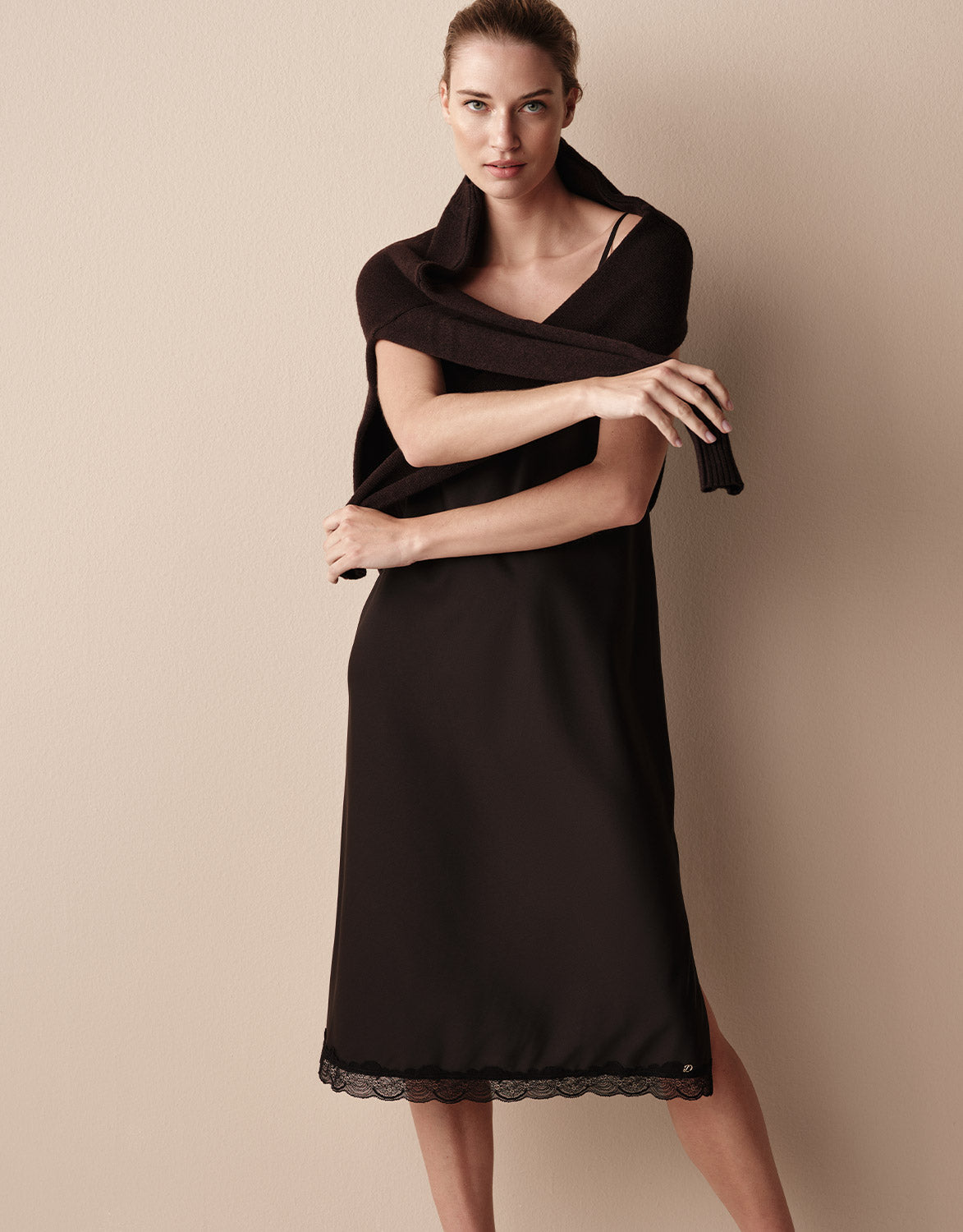 Model im Aurora Black Slipdress mit einem Schal, von der Seite gesehen.