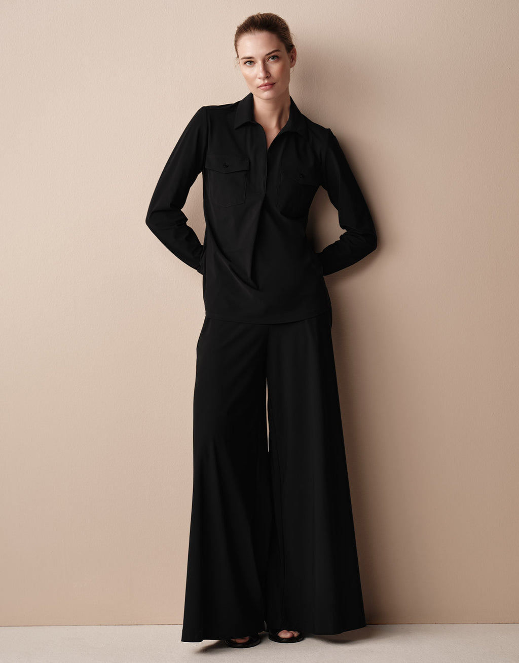 Model standing in the Savona Black trousers in jersey lycra with the Esmee Black blouse.