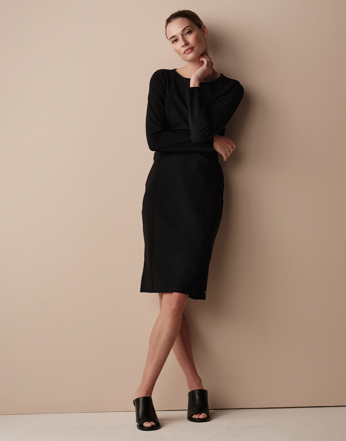 Model standing in the Fenna Black dress in jersey lycra with long sleeves.