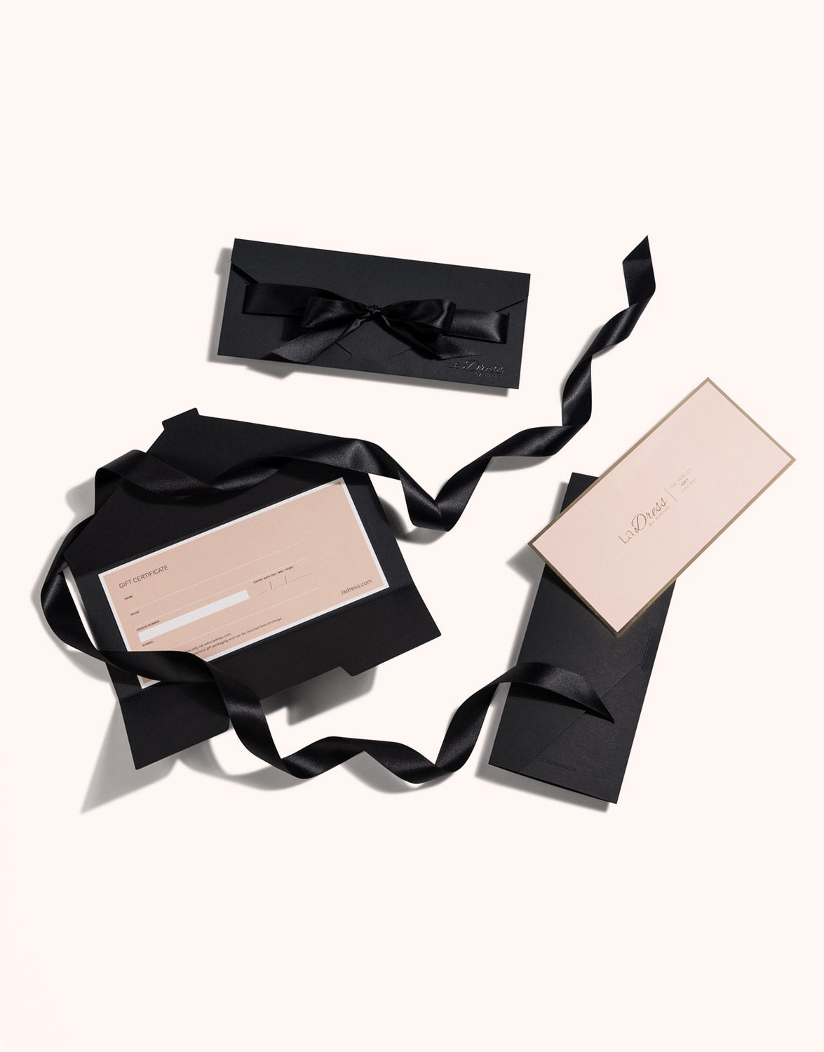 Packshot of the LaDress gift voucher with a black gift box and ribbon.