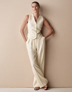 Model standing in the Toledo Ivory trousers in crepe satin with a matching waistcoat.