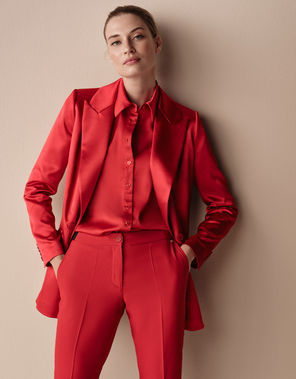 Model standing in the Juliette Raspberry Red Satin blazer in crepe satin with a satin blouse.