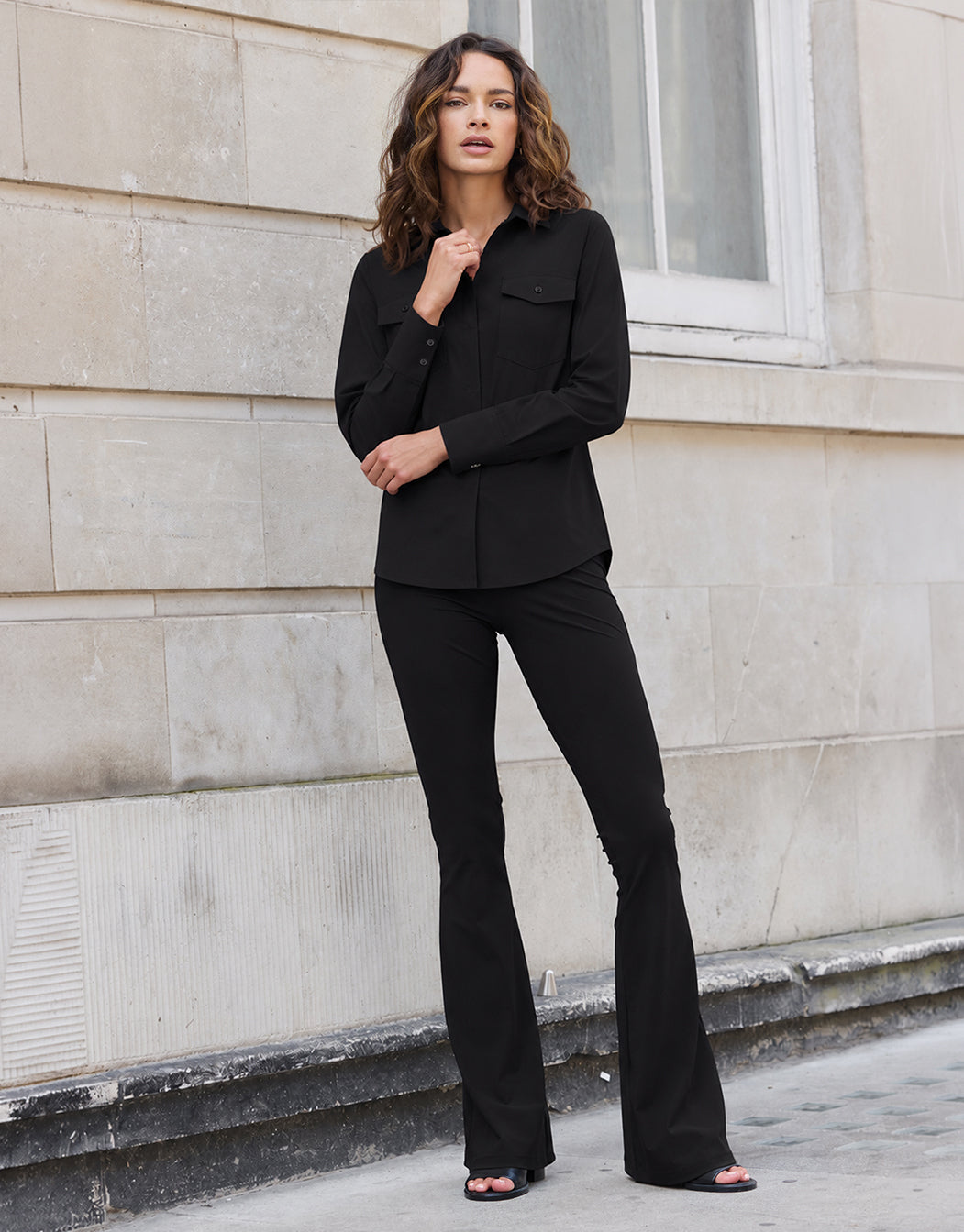 Model standing in the Lima Black trousers in jersey lycra with a black tunic blouse.