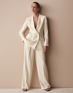 Model standing in the Toledo Ivory trousers in crepe satin with a matching blazer.