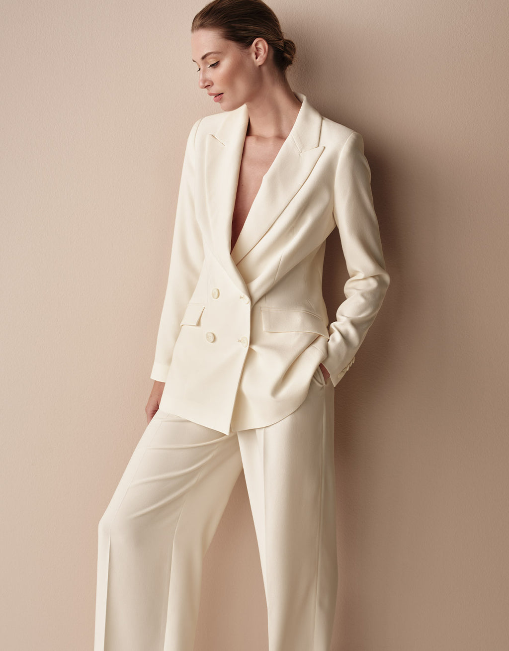 Model standing in the Toledo Ivory trousers in crepe satin with the Loren Ivory blazer.