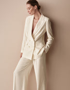 Model standing in the Toledo Ivory trousers in crepe satin with the Loren Ivory blazer.