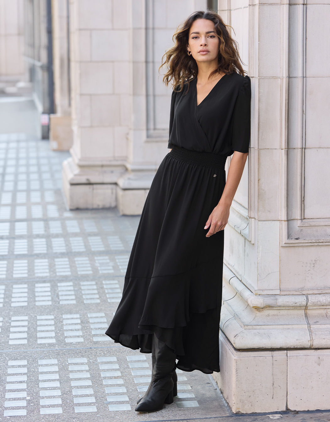 Model standing in the Lotus Black dress in crepe georgette with a wrap front.
