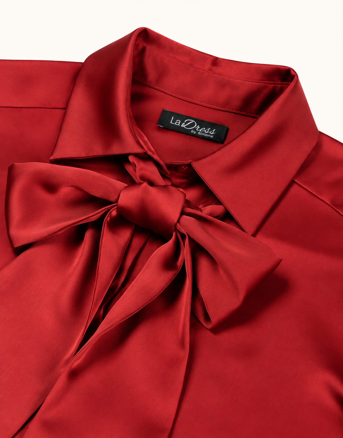 Detailaufnahme der Addy Deep Crimson Bluse aus Satin mit Kragen und Schleife.