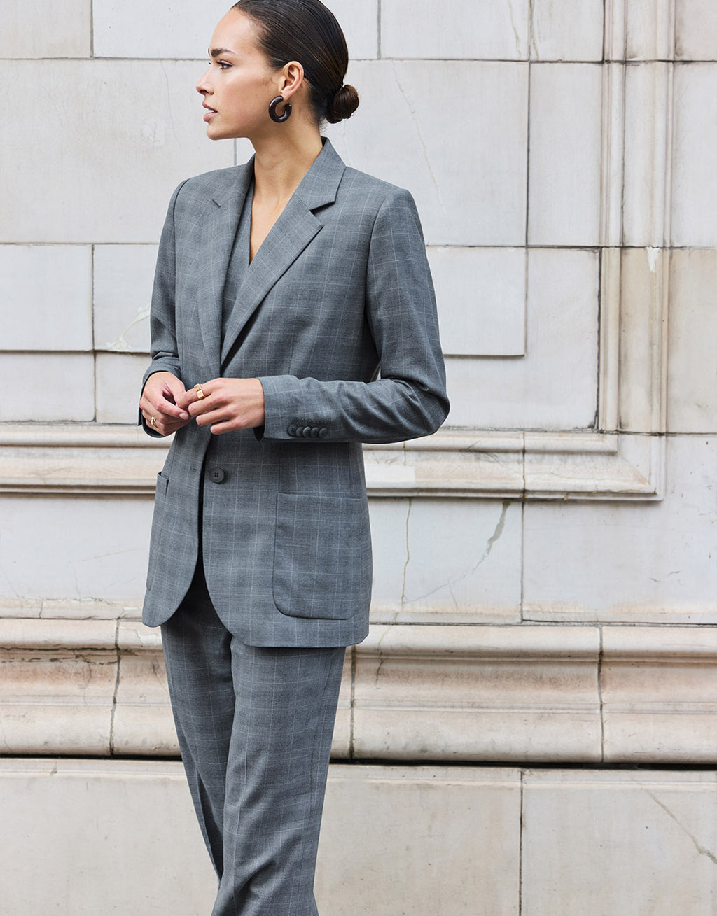 Model seen from the side in the Naples Light Grey Check trousers with the Romee blazer.