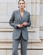 Model standing in the Naples Light Grey Check trousers in stretch woven with the Romee blazer.