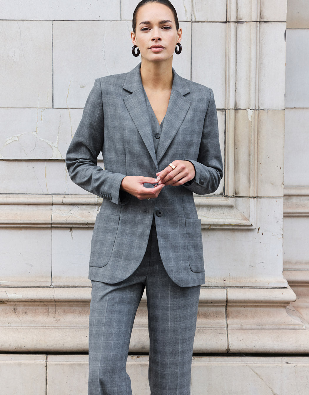 Model standing in the Naples Light Grey Check trousers in stretch woven with the Romee blazer.