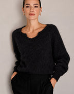 Close-up van een model in de Stefania Black trui van alpacamix, hand in de broekzak.