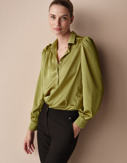 Model standing in the Tilda Lime blouse in satin with black trousers.