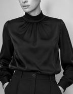 Nahaufnahme der Vittoria Black Bluse aus Satin mit gerafftem hohem Kragen, in Schwarz-Weiß.