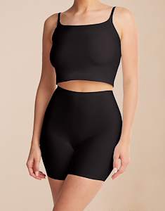 Model standing in the Ginny 2-pack Black/Black shaping shorts in jersey lycra with a black top.