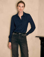 Model standing in the Annie Midnight Blue blouse in jersey lycra with jeans and a black belt.