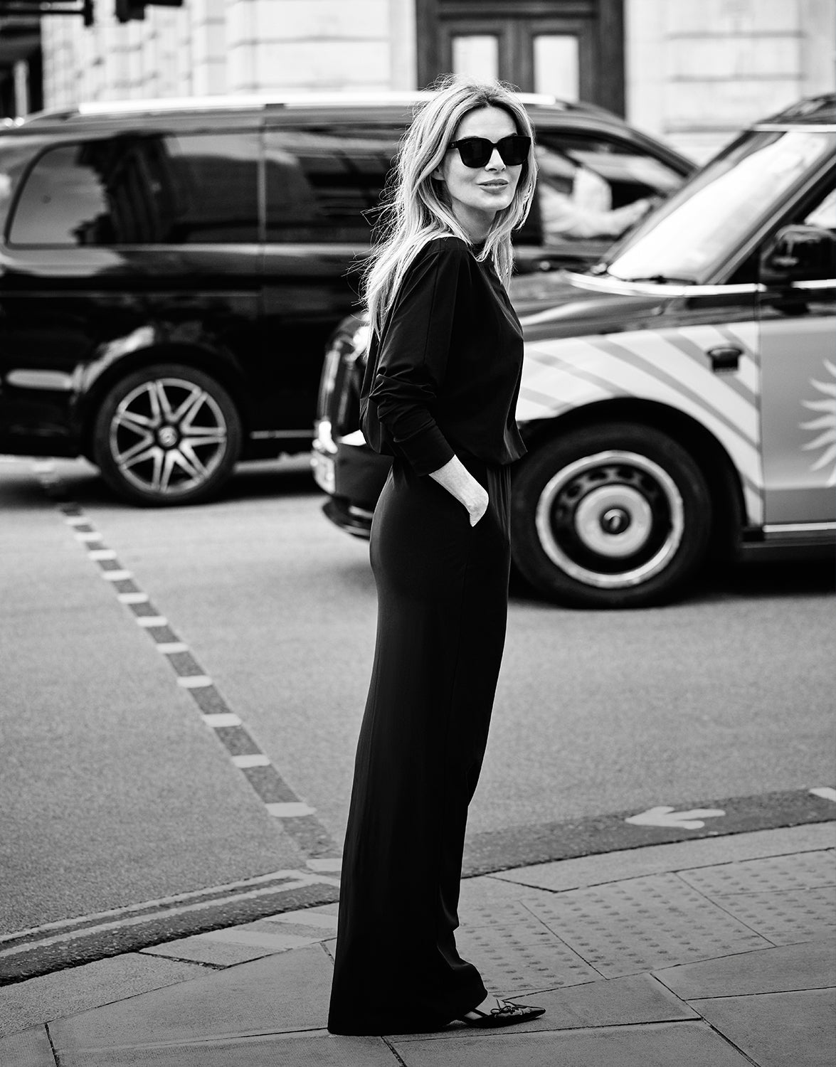 Model standing in the Hillary Black dress in jersey lycra, in a black and white image.