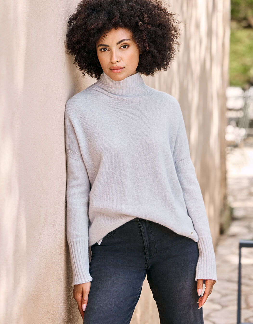 Model wearing the Anna Stone Grey wool sweater with a turtleneck and dark jeans.