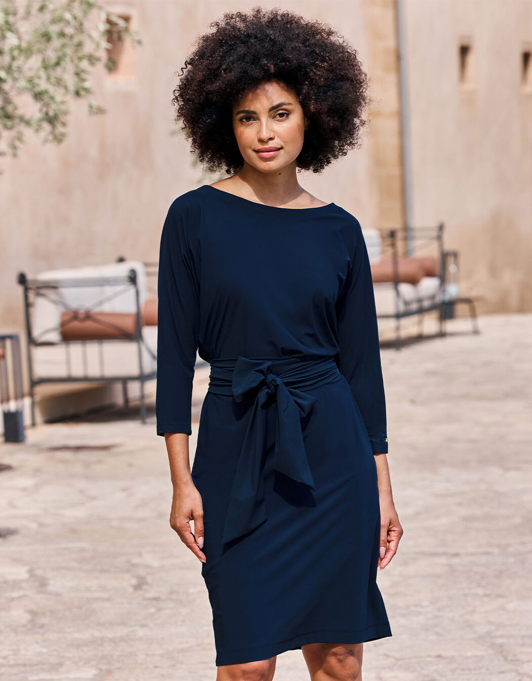 Model standing in the Caroline Midnight Blue dress in jersey lycra with a tie belt at the waist.