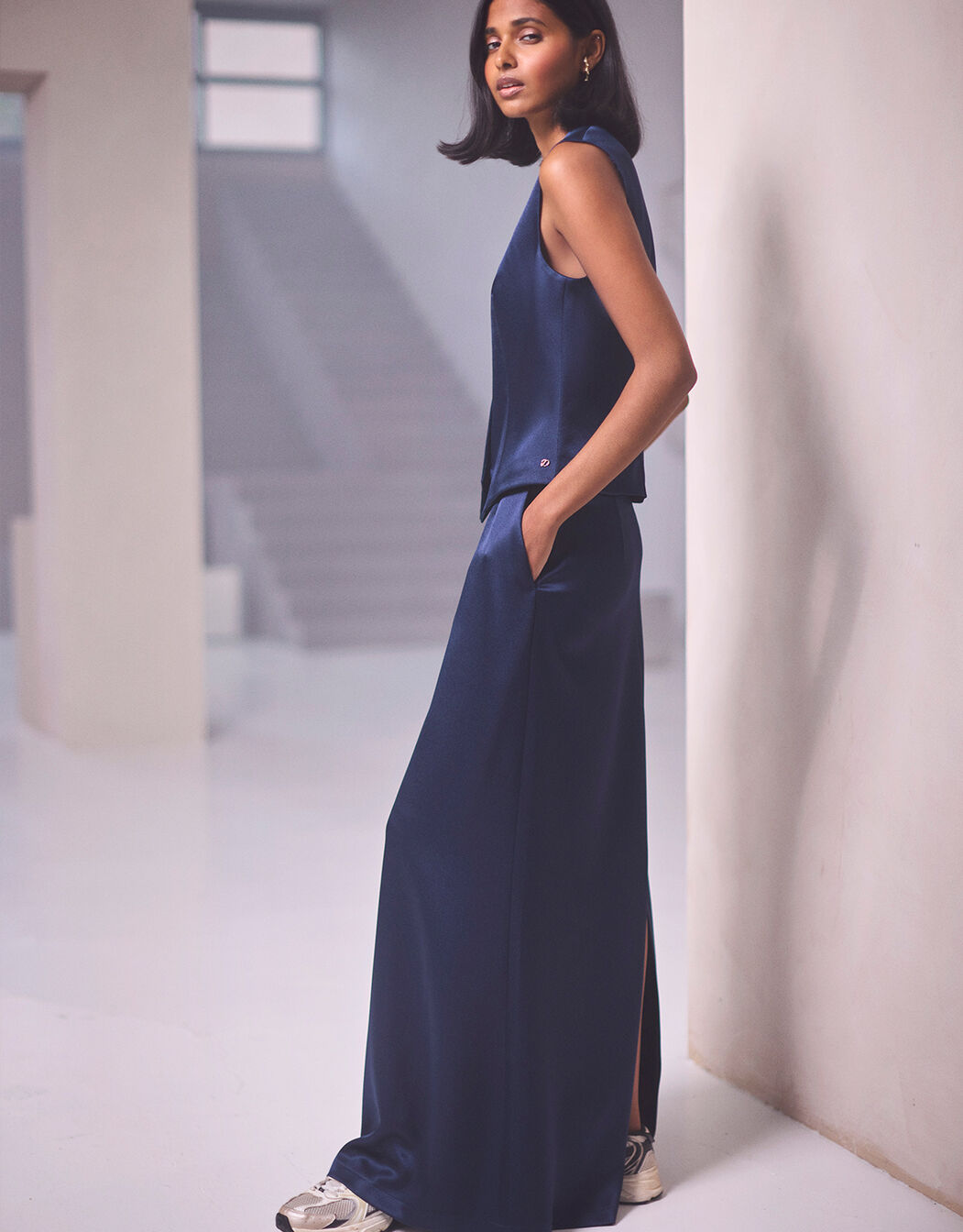 Model standing in the Christy Midnight Blue Satin skirt in crepe satin with a matching top.