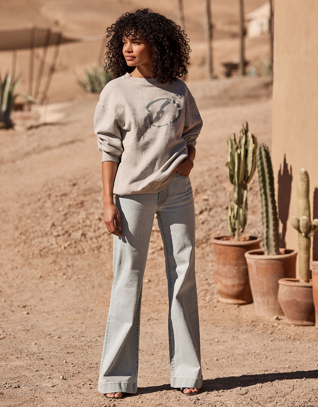 Model standing in the Marisol Light Indigo jeans in stretch cotton with a sweatshirt.